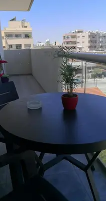 a blue table with a potted plant on a balcony at Loizou Holdings Flat 301 in Larnaka