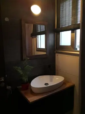 a bathroom with a white sink and two windows at Loizou Holdings Flat 301 in Larnaka