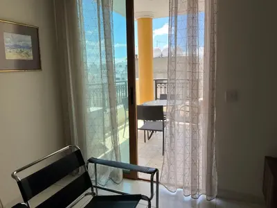a room with a chair and a window with a balcony at Klimentos Flat 58 in Nicosia