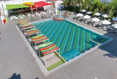 an overhead view of a swimming pool with chairs and umbrellas at JOY Hotel Apts in Ayia Napa
