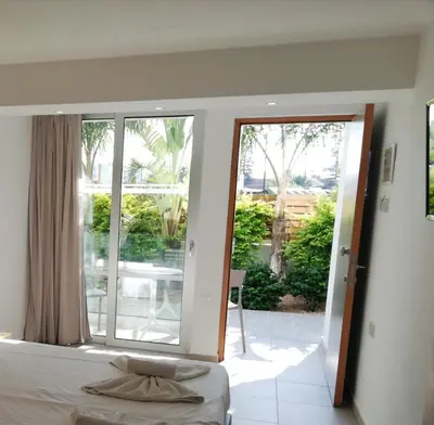 a bedroom with a bed and a large window at JOY Hotel Apts in Ayia Napa