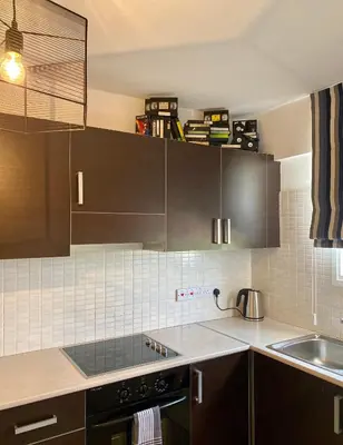 a kitchen with brown cabinets and a sink at Fat Cow Apartment 102 in Livadhia