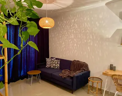 a living room with a blue couch and a blue curtain at Fat Cow Apartment 102 in Livadhia