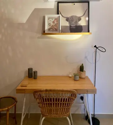 a table with two chairs and a picture of a cow at Fat Cow Apartment 102 in Livadhia