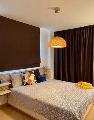 a bedroom with a bed and a large window at Fat Cow Apartment 102 in Livadhia