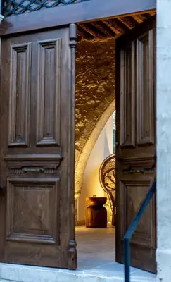 a large wooden door in a room with a chair at The Courtyard Episkopi Guest Houses in Episkopi Lemesou