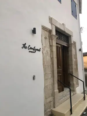 a sign on the side of a white building at The Courtyard Episkopi Guest Houses in Episkopi Lemesou