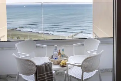 a table and chairs with a view of the ocean at Mackenzie Leo Seafront Suite in Larnaka