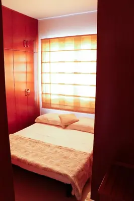 a small bedroom with a bed with a window at Luxury Apartment, near Pinikoudes beach in Larnaka