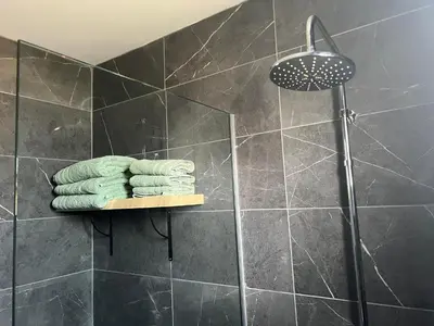 a shower with four towels on a shelf in a bathroom at Luxury Lavender in Larnaka