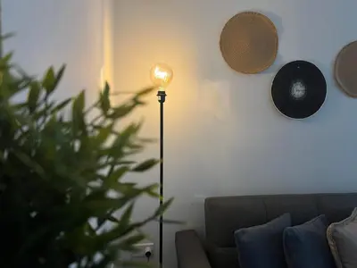 a floor lamp in a living room next to a couch at Luxury Lavender in Larnaka