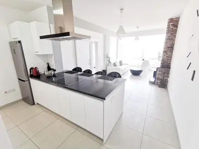 a kitchen with white cabinets and a black counter top at Mackenzie Seaview Paradise in Larnaka