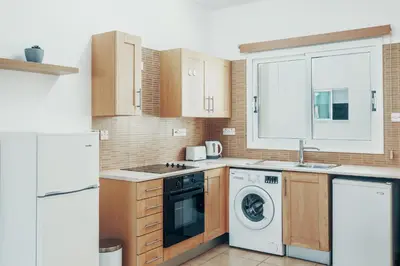 a kitchen with a washer and dryer at Elegant 1 Bedroom Apartment - Great Kings Resort Protaras, Kapparis in Paralimni