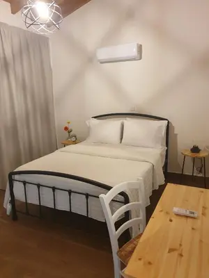 a bedroom with a bed and a wooden table at Melissonas Villas in Phini