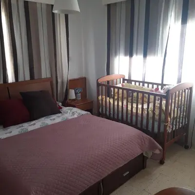 a bedroom with a crib and window with curtains at La Veranda Sea View apartments in Larnaka