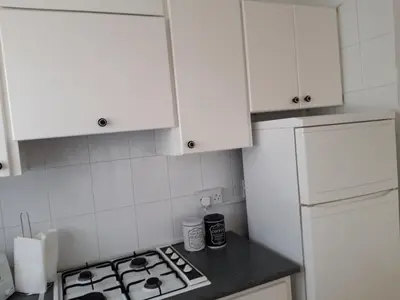 a kitchen with white cabinets and a stove top oven at La Veranda Sea View apartments in Larnaka