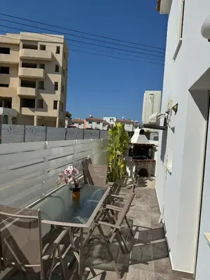 a patio with a table and chairs on a balcony at Villa Naxos in Protaras