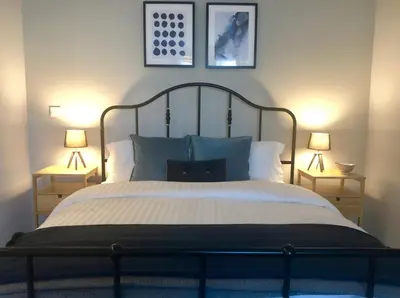a bedroom with a large bed with two lamps at Angel Suites in Nicosia