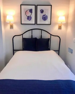 a bedroom with a bed with two pictures on the wall at Angel Suites in Nicosia
