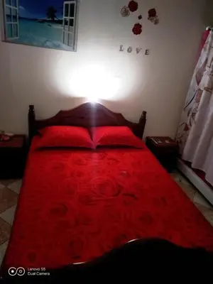 a bed with red sheets and red pillows on it at -= Studio Love =- in Xylophaghou