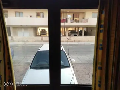 a view of a white car through a window at -= Studio Love =- in Xylophaghou