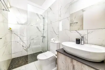 a white bathroom with a sink and a toilet at Olivine Waves in Protaras