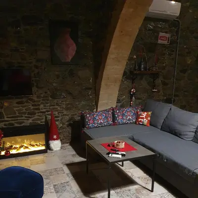 a living room with a couch and a fireplace at Petradaki House in Arakapas