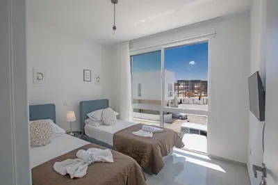 a room with two beds and a large window at Vie Bleu Villas in Protaras