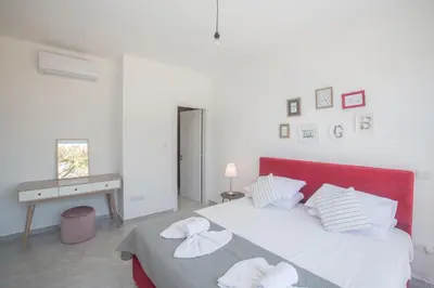 a white bedroom with a bed and a desk at Vie Bleu Villas in Protaras