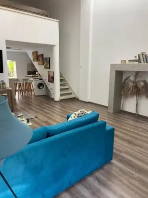 a living room with a blue couch and a kitchen at Modern City Center Appartment Saripolou in Limassol