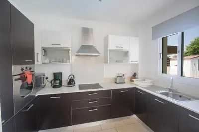a kitchen with black and white cabinets and a sink at Ariella Villa in Protaras