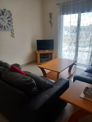 a living room with a couch and a table at BarLee's Apartment in Paralimni
