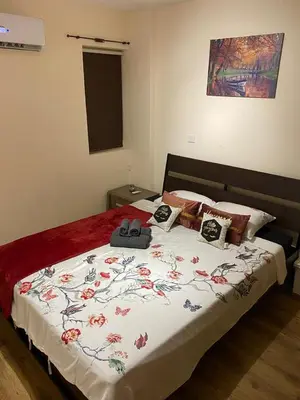 a bedroom with a bed with a floral bedspread at City Comfort Rooms in Larnaka