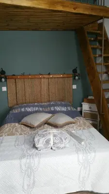 a bed with a wooden head board and a ladder at Magdalene's City House Inn in Larnaka