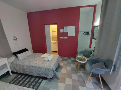 a small bedroom with a bed and a chair at Magdalene's City House Inn in Larnaka