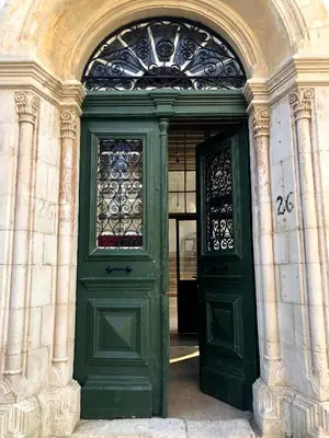 a green door with a window on a building at Le Mat Hostel in Larnaka