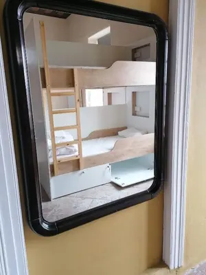 a mirror reflecting a room with a bunk bed at Le Mat Hostel in Larnaka