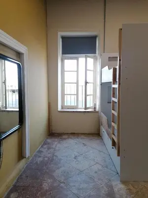 an empty room with a window and a shelf at Le Mat Hostel in Larnaka