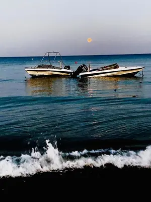 two boats sitting in the water on the beach at Kareem flat in Larnaka