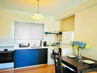 a kitchen with blue cabinets and a table and a refrigerator at Kareem flat in Larnaka
