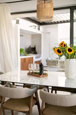 a dining room with a table with a vase of sunflowers at Chris Le Mare Gold Luxury Villa in Protaras