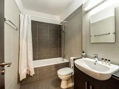 a bathroom with a sink and a toilet and a tub at Mythical Sands Resort in Protaras