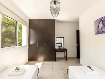 a living room with two white tables and a cabinet at Mythical Sands Resort in Protaras