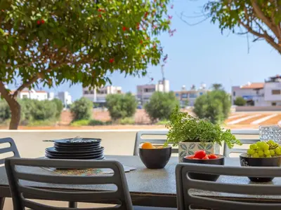 a table with plates and bowls of fruit on it at Mythical Sands Resort in Protaras