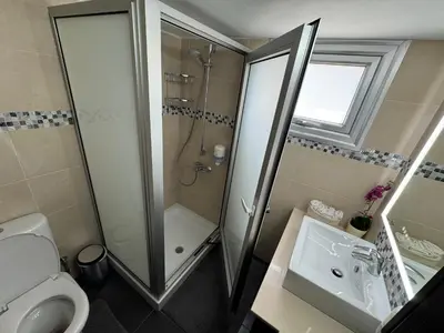 a bathroom with a shower and a toilet and a sink at Topikos Apartments in Ayia Napa