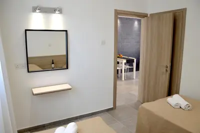 a bathroom with a mirror on a wall with a table at Topikos Apartments in Ayia Napa