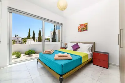 a bedroom with a bed and a large window at Mylos Lifestyle Seaview Villa #21 in Protaras