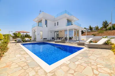 a villa with a swimming pool in front of a house at Mylos Lifestyle Seaview Villa #21 in Protaras