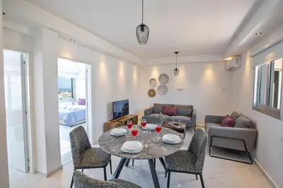 a living room with a table and chairs at Apt Misia Enas - Modern 2 Bedroom Apartment With Sea Views - Close To Ayia Napa in Ayia Napa