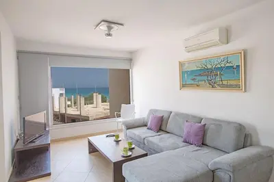 a living room with a couch and a table at Apt Lasonos Asimi - Luxury 3 Bedroom Protaras Apartment - Communal Pool in Protaras